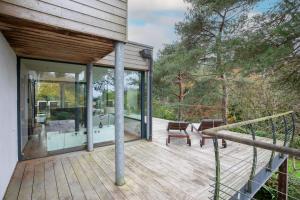 een huis met een houten terras met glazen deuren bij Entre Terre Et Mer in Locquirec