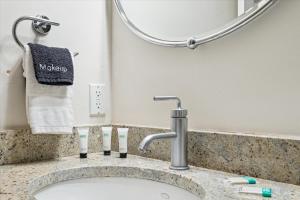 a bathroom sink with a faucet and three toothbrushes at 308 W Taylor Street Garden in Savannah +25 photos