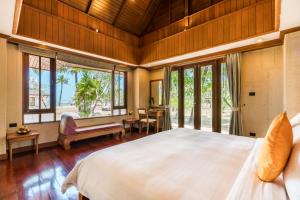 sypialnia z dużym łóżkiem i oknami w obiekcie Andaman Princess Resort & Spa w mieście Ban Pak Ko +65 zdjęć