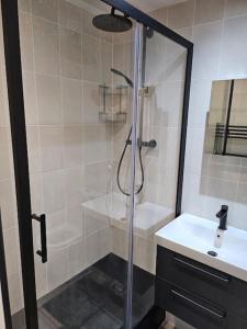 a shower with a glass door next to a white sink at Spacious and Modern Two Bedroom Two Bathroom Flat in Edgware