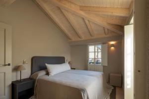 a bedroom with a bed with a wooden ceiling at Casa Juanita in Melide