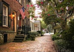 Una calle de ladrillos con una bandera estadounidense en un edificio. en 17 E Jones Garden, en Savannah 31 fotos más