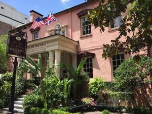 un edificio rosa con una bandera americana encima en 17 E Jones Garden, en Savannah