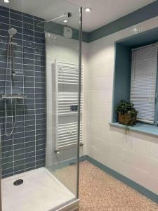una doccia con una porta in vetro in un bagno di Grande maison de charme avec piscine 11 pers a Charras Altre 50 foto