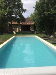 una grande piscina blu davanti a una casa di Grande maison de charme avec piscine 11 pers a Charras