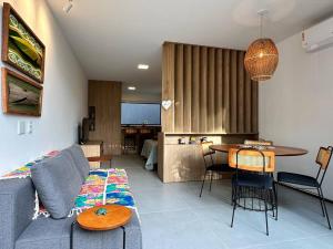 a living room with a blue couch and a table at Villa Naluri - Studio Iamandu A001 in Japaratinga