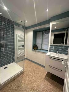 un bagno con doccia in vetro e lavandino di Grande maison de charme avec piscine 11 pers a Charras
