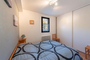 a bedroom with a bed and a window at Le Village des Thermes in Vignec