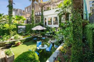 a backyard with a table and chairs and plants at 16 E Jones Carriage House in Savannah