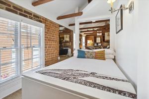 a bedroom with a large bed and a brick wall at 16 E Jones Carriage House in Savannah