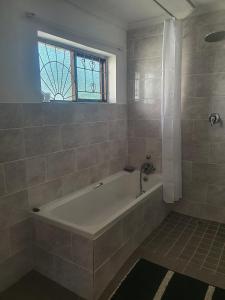 un bagno con vasca e finestra di Beautiful cottage a East London