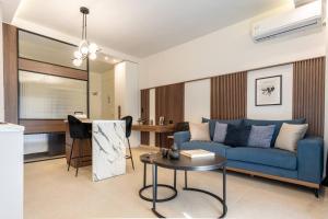 a living room with a blue couch and a table at R&b Living Experience in Alexandroupoli