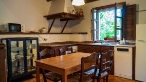 a kitchen with a wooden table and a kitchen with a sink at Casa del Sur El Collau in Porrúa