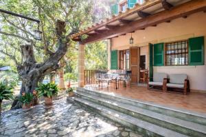 ein Haus mit einer Terrasse mit einem Baum in der Unterkunft Villa Ca'n Tabou in Selva