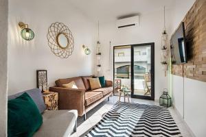 a living room with a couch and a tv at 212 Aurora sol - CASINHA DO SOL in Praia do Carvoeiro