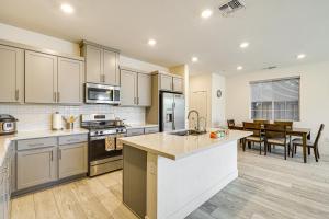 a large kitchen with white cabinets and a table at 8 Mi to Lincoln Park Family-Friendly Tracy Home in Tracy
