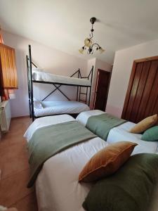 ein Schlafzimmer mit 3 Betten und Kissen darauf in der Unterkunft El Moral Centro de Turismo Rural in Valdecañas