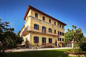 un grande edificio giallo con balconi e un cortile di Giardino Ferrari a Verona