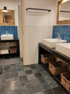 a bathroom with two sinks and two baskets at Sfeervolle groepsaccommodatie met hottub in natuurgebied in Wateren