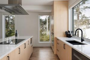 a kitchen with a sink and a large window at Le Nordet - SPA & Play room in Saint Come
