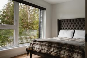 a bedroom with a bed and a large window at Le Nordet - SPA & Play room in Saint Come
