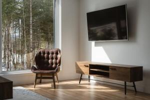 a living room with a chair and a tv at Le Nordet - SPA & Play room in Saint Come +60 photos