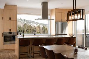 a kitchen with a table and a large window at Le Nordet - SPA & Play room in Saint Come