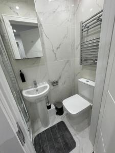 a white bathroom with a sink and a toilet at London Euston 4 minute walk away in London