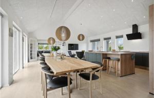 a kitchen and dining room with a wooden table and chairs at Lovely Home In Hadsund With Wifi in Hadsund