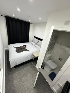 a small room with a bed with a black curtain at London Kings Cross Room w Bath in London