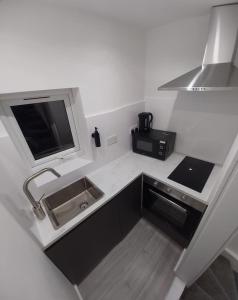 a small kitchen with a sink and a microwave at London Kings Cross Room w Bath in London