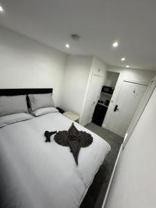a bedroom with a large white bed with black clothes on it at London Kings Cross Room w Bath in London