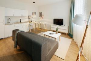 ein Wohnzimmer mit einem Sofa und einer Küche in der Unterkunft Goldkind Feine Wohn- & Schlafstuben in Heppenheim an der Bergstrasse