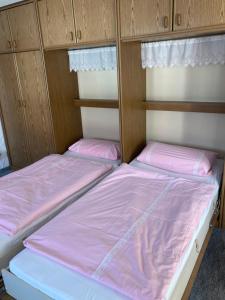two beds in a bunk room with pink sheets at Alpenrose komfortable Ferienresidenz in Oberstdorf