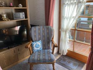a living room with a chair and a television at Alpenrose komfortable Ferienresidenz in Oberstdorf