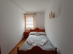 a bedroom with a bed with two towels on it at InmoCyma Pico Posets Benasque in Benasque
