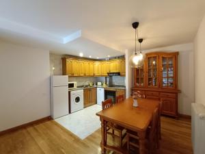 a kitchen with a table and a white refrigerator at InmoCyma Pico Posets Benasque in Benasque