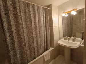 a bathroom with a sink and a shower curtain at InmoCyma Pico Posets Benasque in Benasque +18 photos