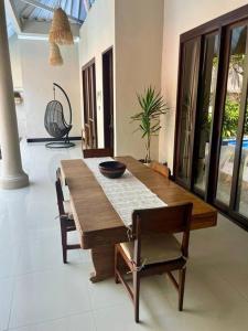 a dining room with a wooden table and chairs at Stylish & quiet Seminyak pool villa in Seminyak