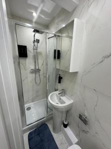 a white bathroom with a sink and a shower at Central London Zone 1 Room wbath in London