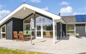 a pavilion with chairs and an umbrella on a deck at Holiday Home Kuskevej Jerup in Jerup