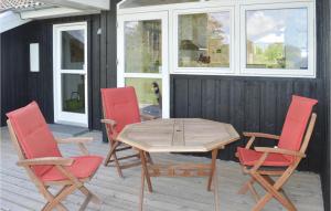 a wooden table and four chairs on a patio at Holiday Home Kuskevej Jerup in Jerup +21 photos
