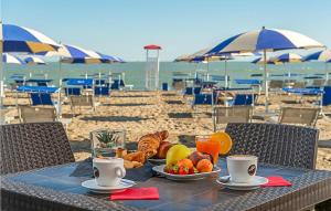 a table with a plate of food on the beach at V4 Zona Verde in Isola Albarella