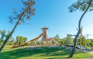 a playground with a slide in a park with trees at V4 Zona Verde in Isola Albarella