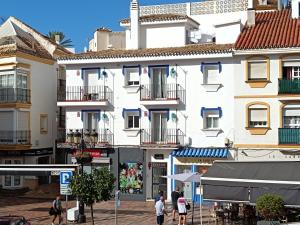 a large white building with people walking on a street at Acogedor apt en casco historico in Marbella