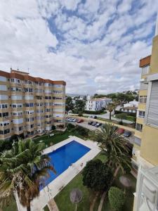 an apartment complex with a swimming pool and palm trees at Sea View La Cala 506 in Mijas Costa