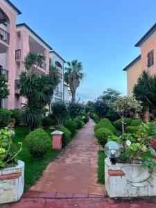 a walkway between two buildings with trees and bushes at Alloggio Residence Sa Tanca in Valledoria