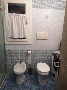 a small bathroom with a toilet and a sink at Alloggio Residence Sa Tanca in Valledoria +3 photos