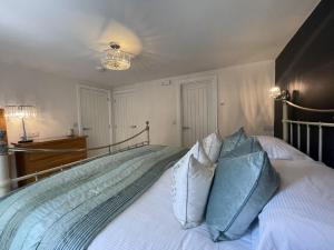 a bedroom with a large bed with blue pillows at Bridge Mews in Keswick