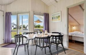 a dining room with a table and chairs and a bed at Amazing Home In Ringkøbing With Sauna in Ringkøbing